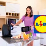 Una donna che usa una friggitrice ad aria in cucina