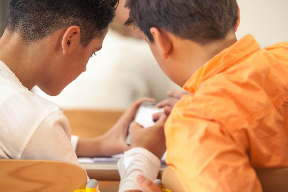 Ragazzi giocano con il telefonino in aula
