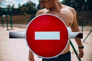 ragazzo a petto nudo e segnale di divieto