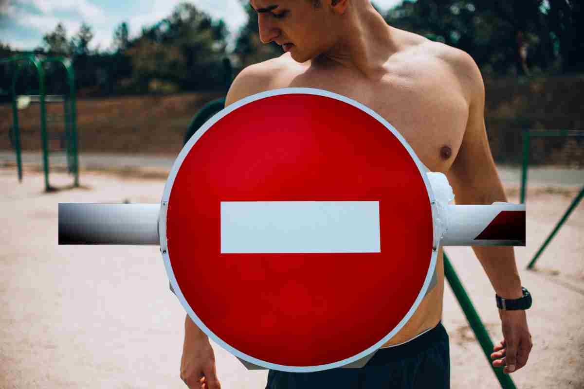 ragazzo a petto nudo e segnale di divieto
