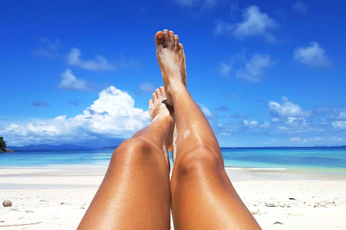 Ragazza si abbronza in riva al mare